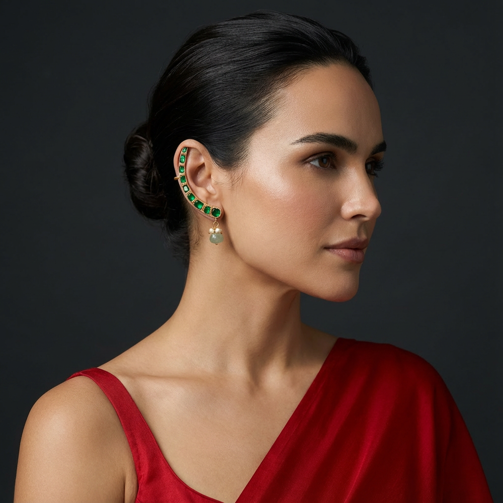 The Emerald Arc Ear Cuff with vivid emerald stones and bold sculptural gold design by Ozel